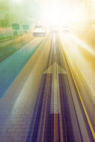 Rue urbaine en effet de vitesse, flèche au sol pointant vers une lumière vive à l’horizon